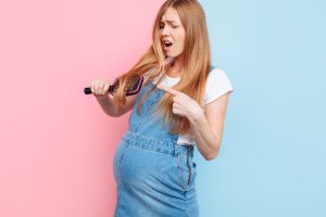 Pregnant Women Looking At Loose Hair On Brush